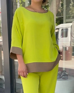 Close-up of lime green loungewear set with brown contrast stitching on cuffs and hem