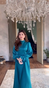 Détail d'une robe élégante en satin émeraude avec manches lanternes et col montant chic