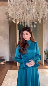 Détail de la robe longue en satin bleu paon avec poignets à volants et col montant chic