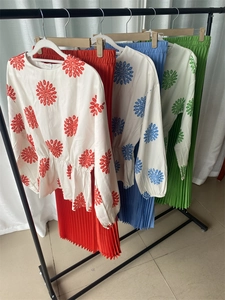 Detail of pleated midi skirt sets with floral long sleeve tops in red blue and green