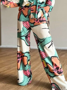 Women's floral print high-waisted wide-leg pants with vibrant abstract patterns