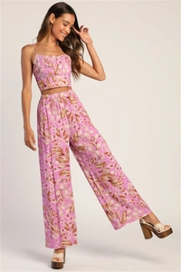 Detail of high-waist wide-leg trousers with tropical leaf print and flowy fabric texture