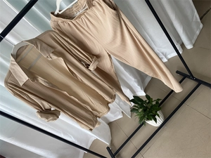 Détail d'un ensemble deux pièces plissé beige clair avec chemise longue et pantalon élastique