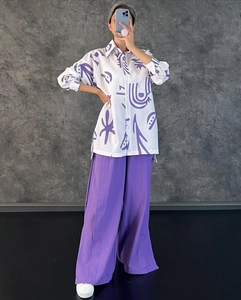 Détail de l'imprimé violet artistique sur chemise décontractée et pantalon large fendu