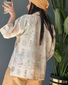 Detailed back view of a white cotton linen shirt featuring hand-drawn plant patterns
