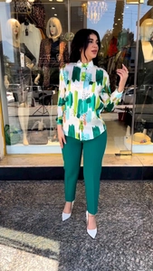 Detail of artistic print long sleeve shirt and matching dark green tailored trousers set