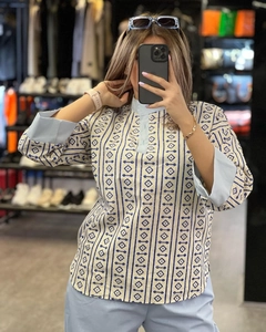 Detail of linen print shirt featuring color-block cuffs and geometric blue patterns