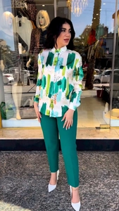 Detail of printed long-sleeve shirt paired with dark green slim-fit trousers on model