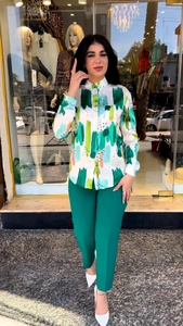 Detail of printed long-sleeve shirt paired with high-waist green trousers for women