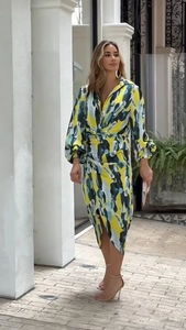 Détail de la robe mi-longue imprimée à col en V avec motifs abstraits et ourlet asymétrique