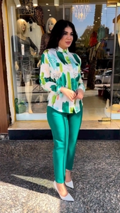 Detail of printed long-sleeve shirt paired with emerald green high-waisted trousers set