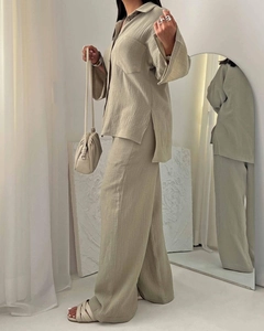 Detail of the olive green crinkle fabric texture on loose shirt and high waist trousers