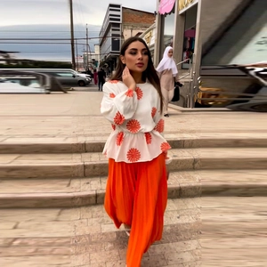 Women's two-piece set featuring a floral long sleeve top and orange pleated wide-leg pants