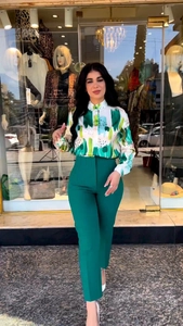 Detailed view of printed long sleeve shirt paired with dark green high waist trousers