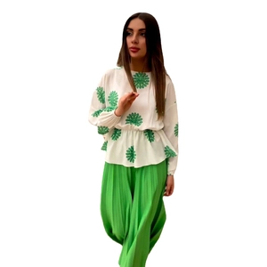 Women's two-piece set featuring a white floral long-sleeve top and green pleated wide-leg pants