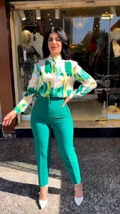 Detail view of abstract print long sleeve shirt paired with high waist green trousers