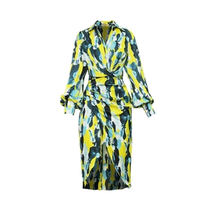 Détail d'une robe à manches longues, col en V, imprimé abstrait jaune et nœud à la taille