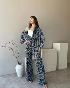 Détail d'un ensemble chemise et pantalon à imprimé léopard avec des accessoires sobres