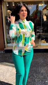 Detail of floral printed long-sleeved shirt and green high-waisted trousers set for women