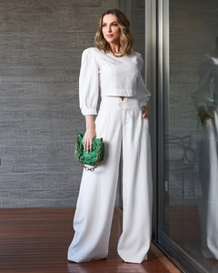 Detail of white two-piece set featuring lantern sleeve crop top and wide-leg pants