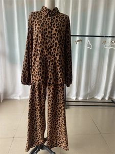Détail des boutons de chemise léopard et du pantalon large à taille haute sur mannequin