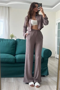 Detailed view of grey-purple pleated fabric texture on a two-piece shirt and pants set