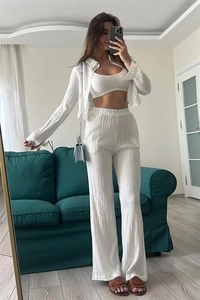 Detailed texture of white three-piece set with embossed puff sleeve shirt and wide pants