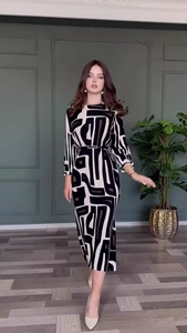 Detail of elegant geometric print dress with slim black belt and abstract pattern