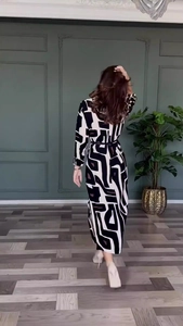 Back view of elegant long sleeve dress with black and white geometric print and waist belt
