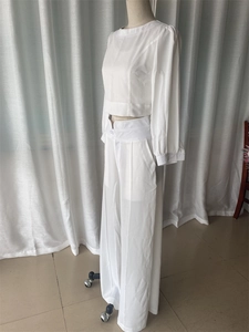 Detail view of white two-piece set featuring cropped puff-sleeve top and wide-leg trousers