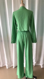Detail view showing the pleated texture and elastic waist of the green two-piece outfit