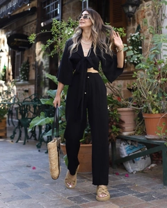 Detail of black two-piece set featuring flare sleeves and drawstring high-waist pants
