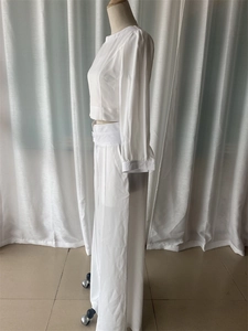 Detail view of white two-piece set featuring a cropped long sleeve top and wide leg pants