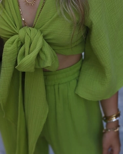 Detail of green crepe fabric two-piece set with front-tie knot and pleated waist