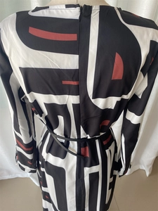 Detail of elegant geometric print long dress with back zipper and slim black belt