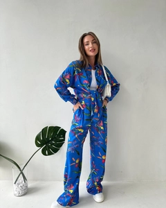 Detail of vibrant blue floral print set showing drape of long sleeve shirt and wide pants