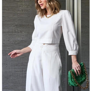 Women's white two-piece set featuring cropped long sleeve top and high-waist wide-leg pants