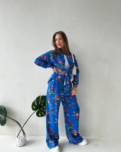 Close-up of vibrant tropical floral print on a blue high-waist wide-leg pant set