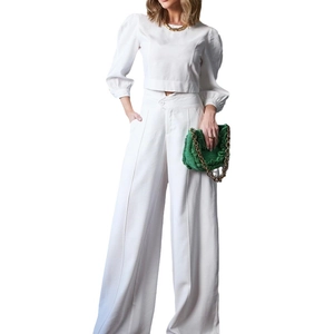 Women's white two-piece set featuring a puff sleeve crop top and high-waisted wide-leg pants