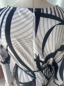 Detail view of the back invisible zipper and geometric stripe print on long dress