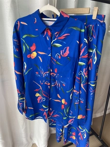 Detail of vibrant tropical floral print on blue long-sleeve shirt and matching trousers