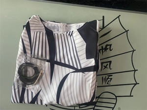 Detailed flat lay of black and white geometric print dress with matching thin black belt