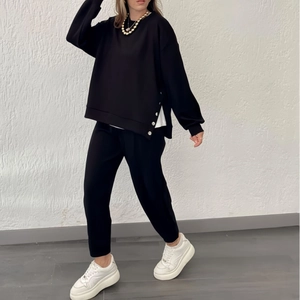 Women's black casual tracksuit with long sleeve top and pants featuring button slit details