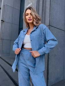 Detail view of blue velvet corduroy set featuring metal buttons and ribbed texture fabric