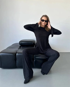 Detailed texture of black ribbed knit two-piece set on a professional model
