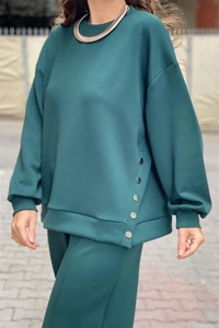 Detail of dark green tracksuit featuring metal chain collar and side button slit design