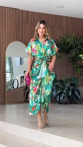 Close-up detail of green tropical floral print dress with waist twist knot design