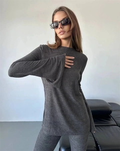 Detail of dark grey ribbed knit fabric showing flared sleeves on two-piece set