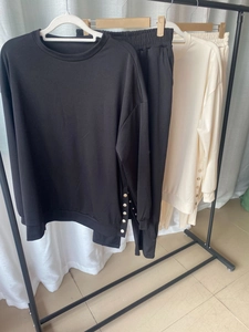 Close-up of stylish knit lounge set featuring metal buttons and side slit sleeve details
