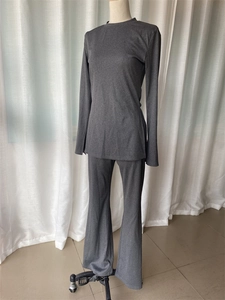 Detail view of dark grey knitted slim-fit long sleeve top and flared trousers set